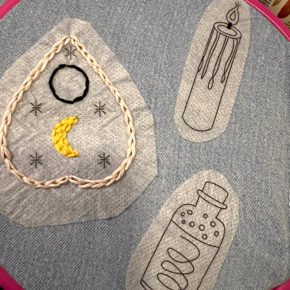 Witchy embroidery patterns stitched onto denim. Shown: planchelle, candle and bottle.