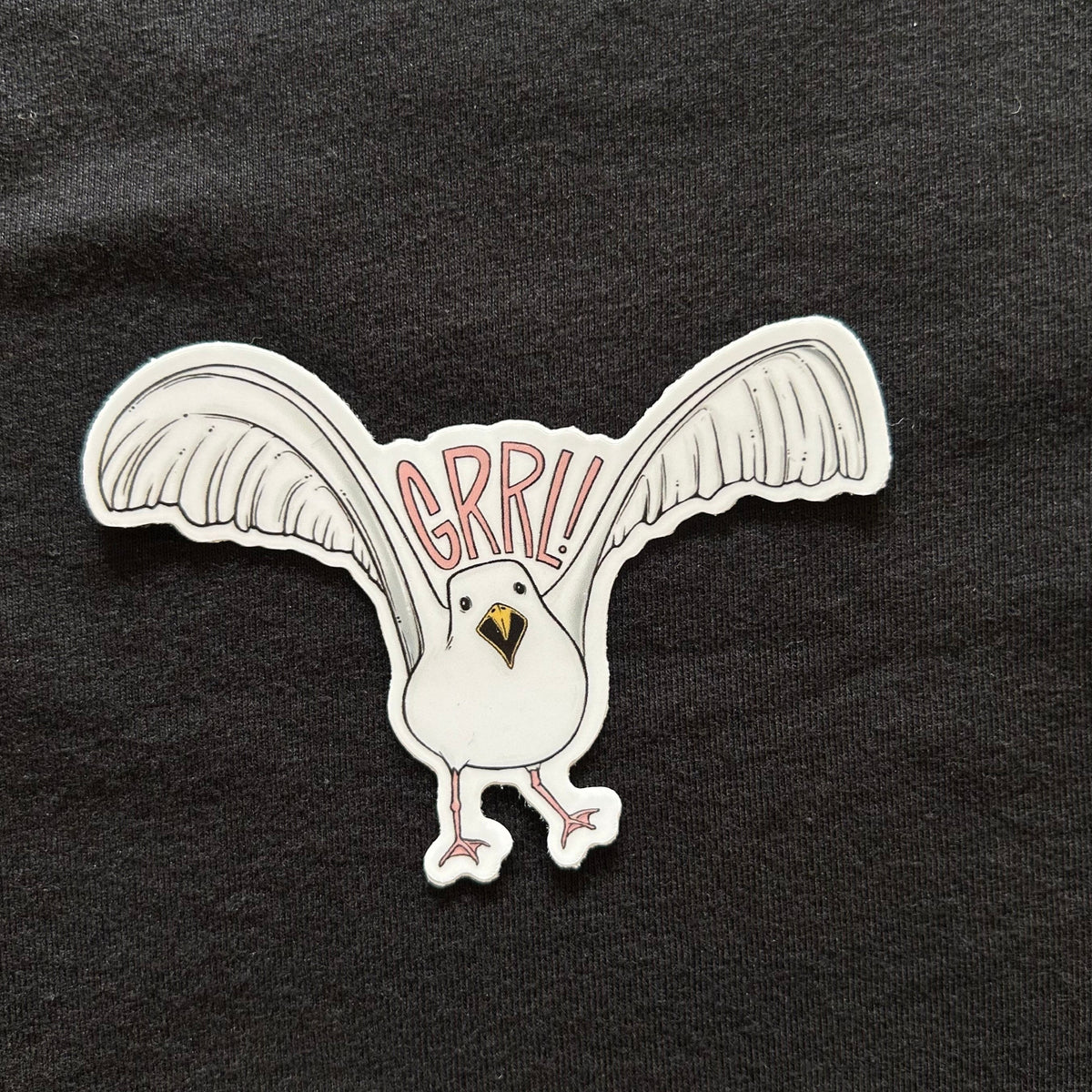 A sticker depicting a seagull in flight with the word "GRRL!" above it