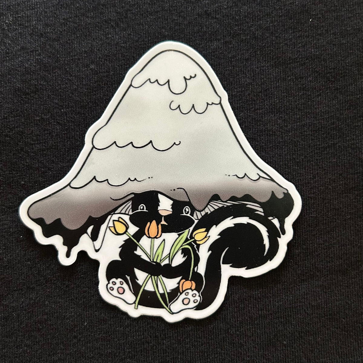 Sticker of a skunk holding flowers under a mushroom on a black background