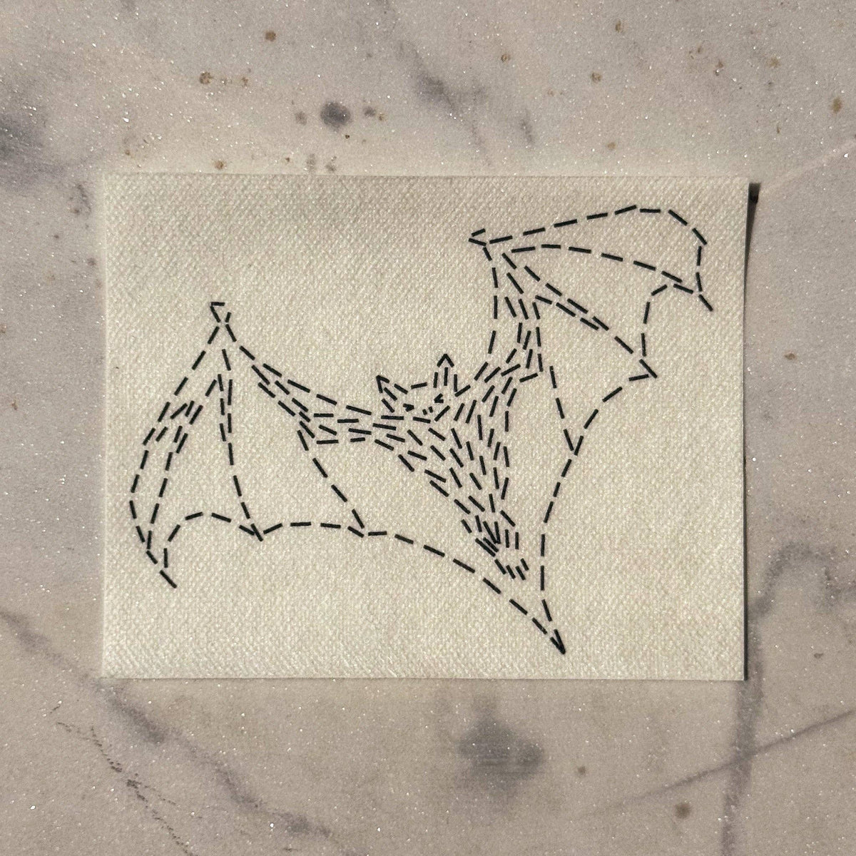 Visible mending pattern of a bat in flight against a marble background 