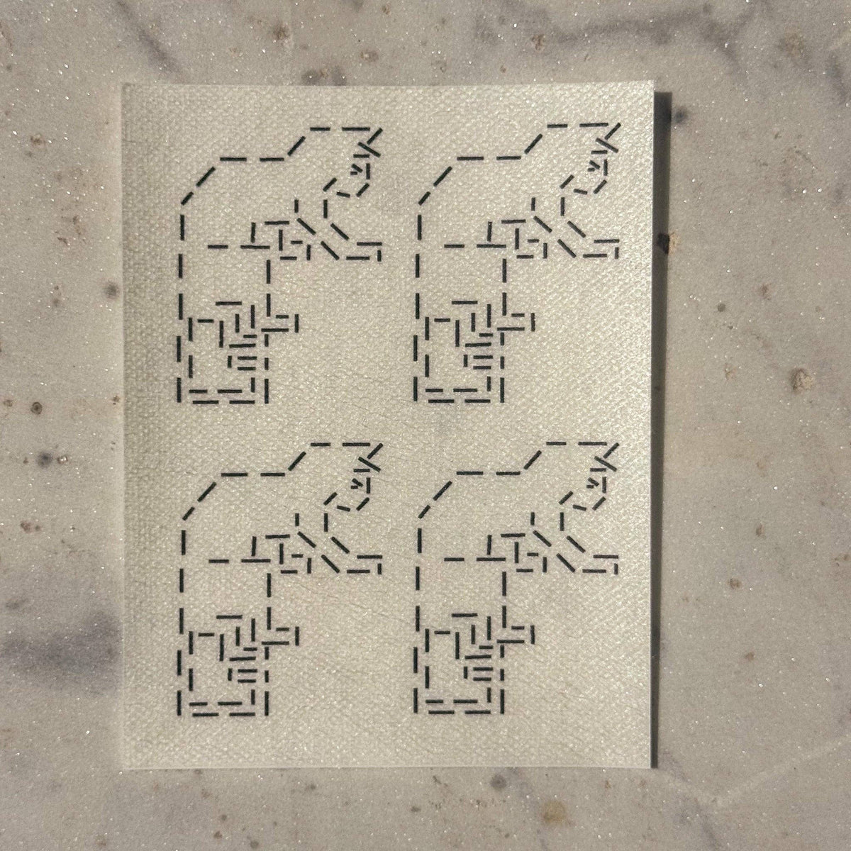 Visible mending guide sticker featuring a repeating design of four cats