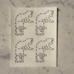 Visible mending guide sticker featuring a repeating design of four cats