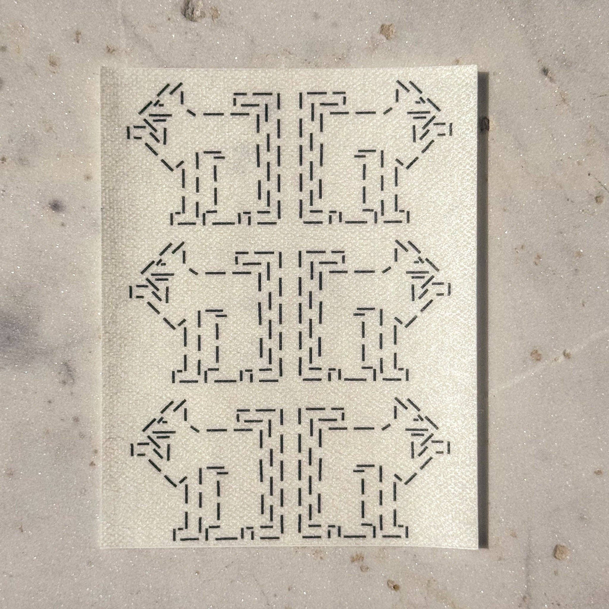 Visible mending guide sticker with a repeating pattern of six cats licking their paws. 