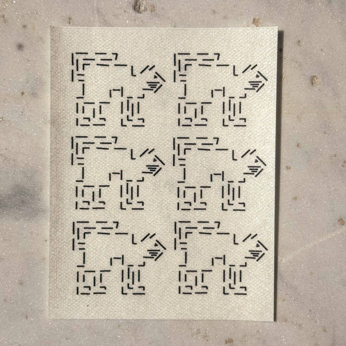 Visible mending guide sticker featuring a repeating pattern of six cats with their tails up. 