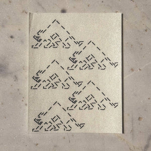 Visible mending guide sticker of five triangle-shaped cats. 