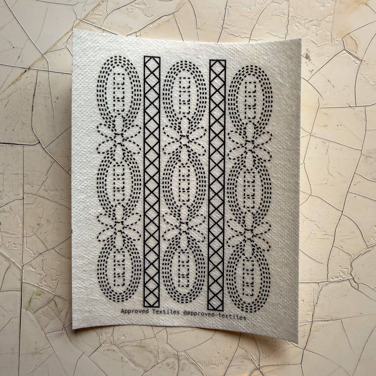 Visible mending guide sticker featuring daisies and ovals in a pattern with diamonds inside of long rectangles. 
