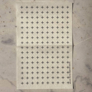 Visible mending guide sticker of many rows of spaced-out plus signs