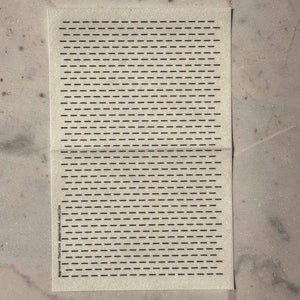Visible mending guide sticker of many rows of horizontal lines against a marble background. 