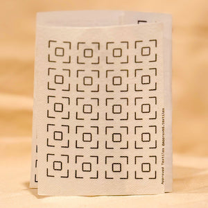 Visible mending pattern sticker featuring a grid of large squares with smaller squares inside. 
