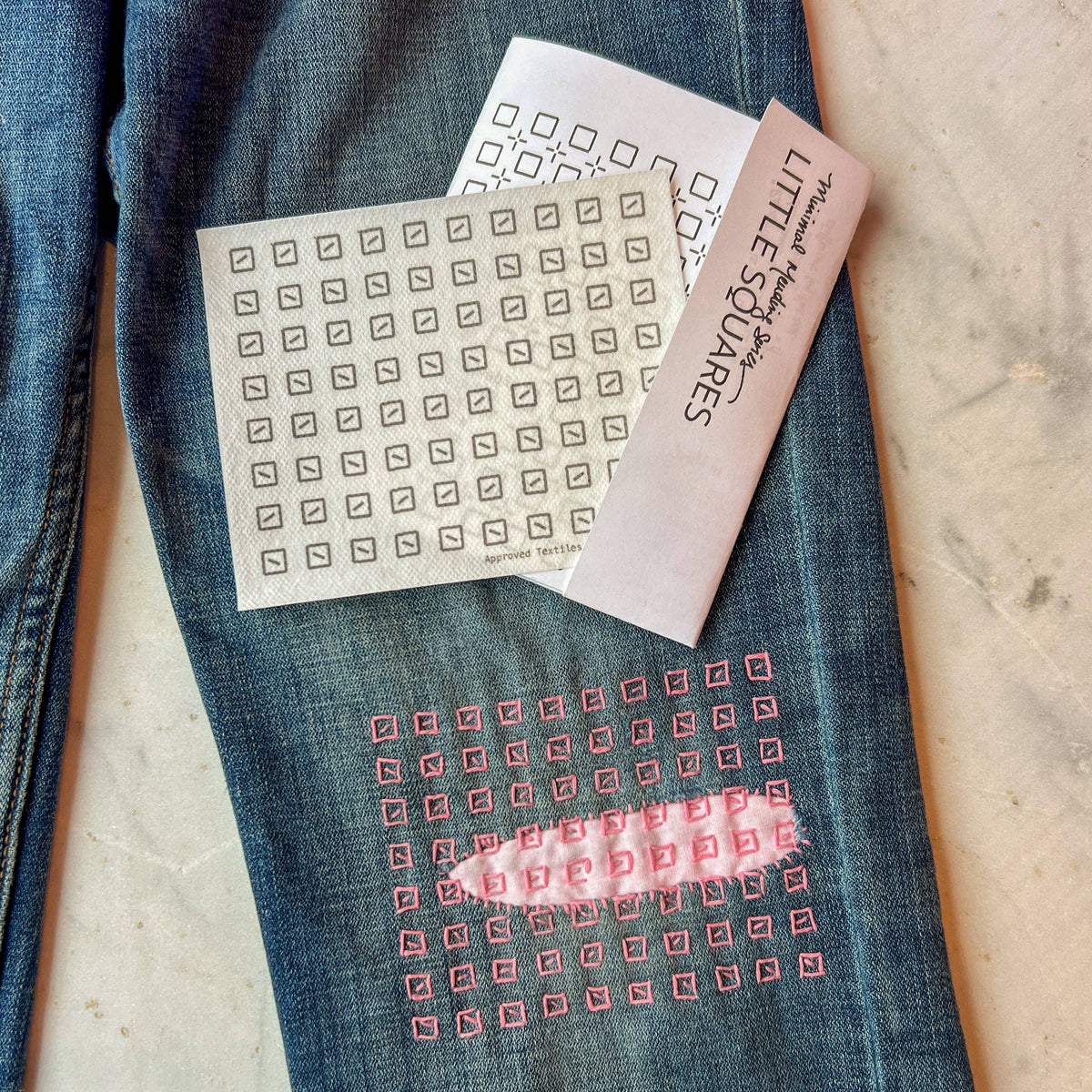 Embroidery design on jeans with a pattern nearby. 