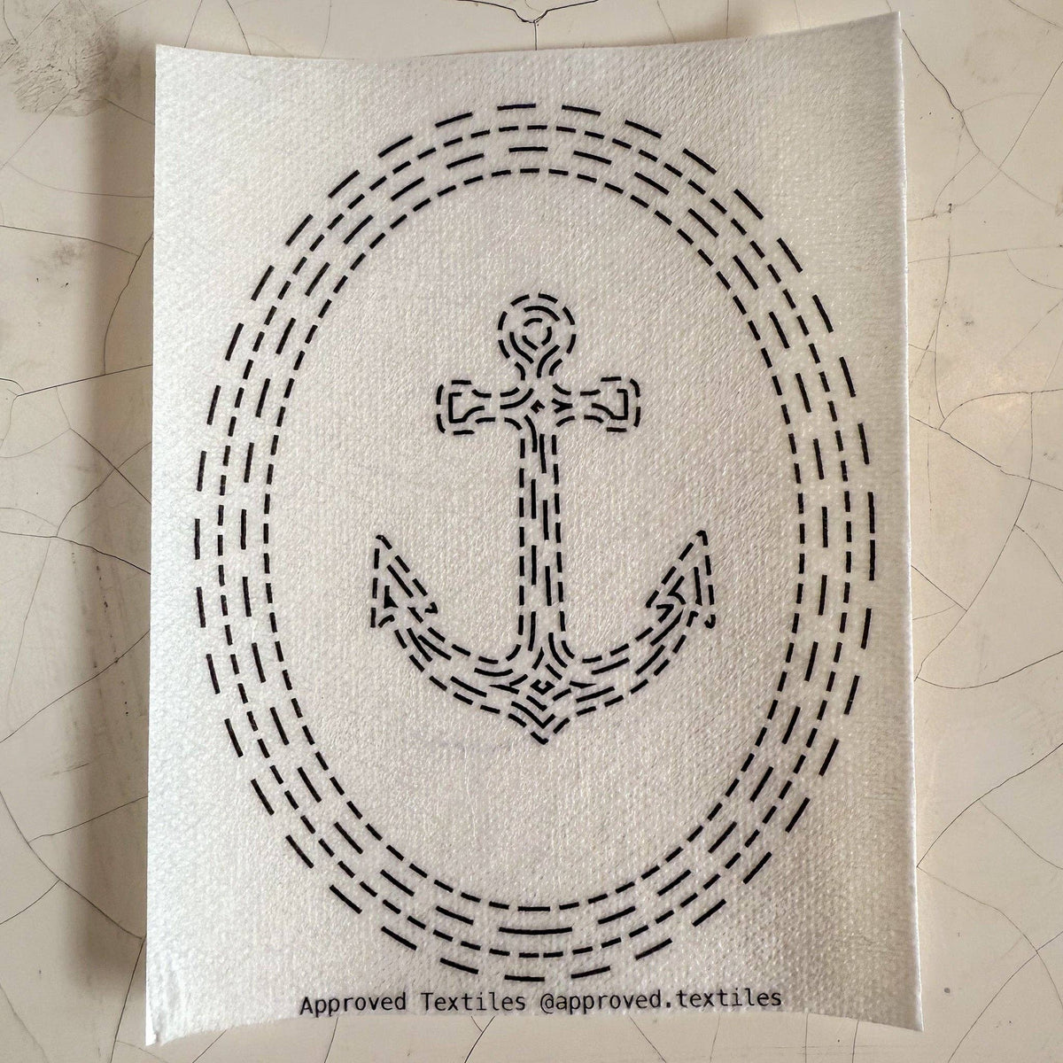 Visible mending pattern sticker featuring an anchor surrounded by concentric ovals