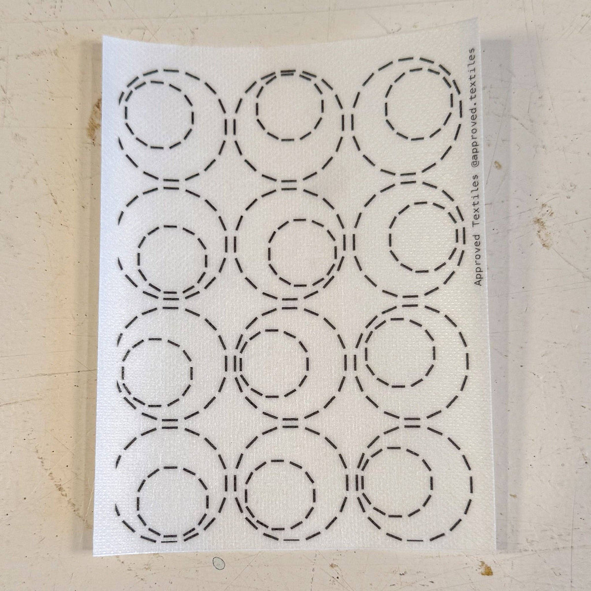 Visible mending pattern sticker featuring a grid of 3x4 circles with smaller circles within them. 