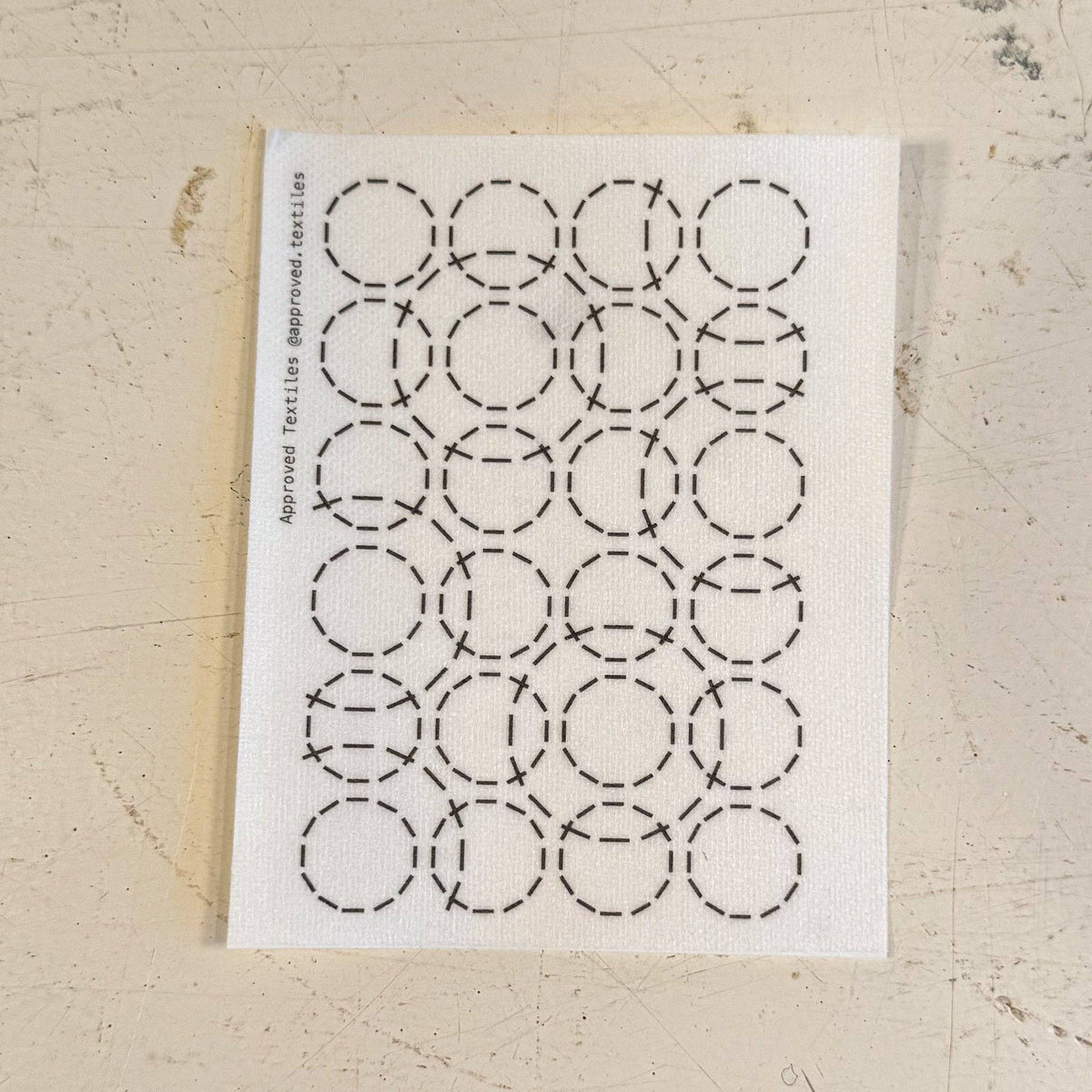 Visible mending pattern sticker of a grid of 4x6 small circles with larger circles overlapping on top. 