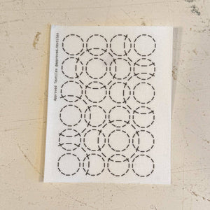 Visible mending pattern sticker of a grid of 4x6 small circles with larger circles overlapping on top. 