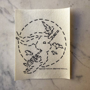 Visible mending pattern sticker featuring a witch riding on a broomstick silhouetted against a full moon with three bats. 