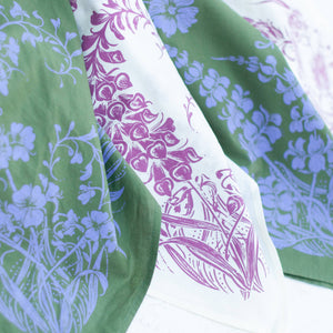 Set of floral-patterned green and purple bandanas on a white background. 