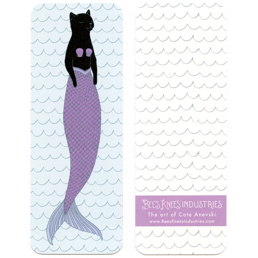 Bookmark with mermaid cat illustration with a purple tail on a wavy pattern background on one side, and a blue scallop pattern on a white background on the other, featuring the brand 'Bees Knees Industries'.