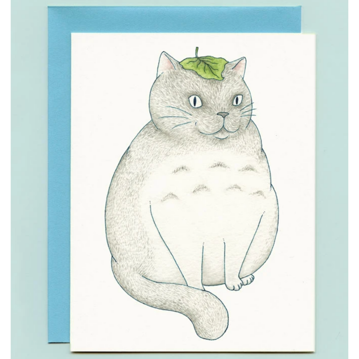 A card with an illustration of a round cat with a leaf on its head. 