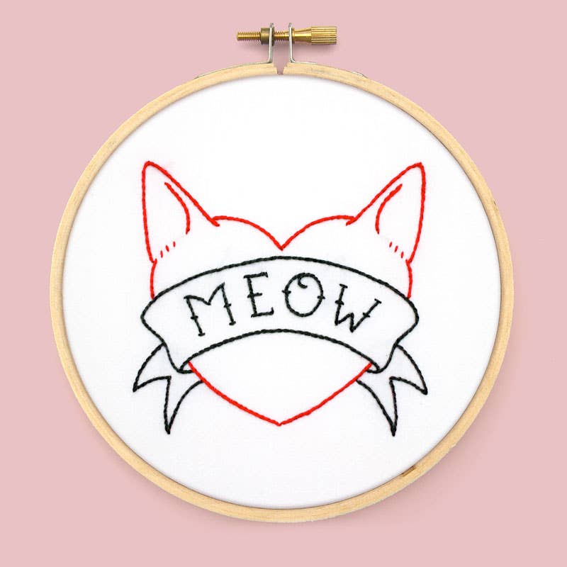 Embroidery hoop with a cat-themed design and 'MEOW' text on a pink background