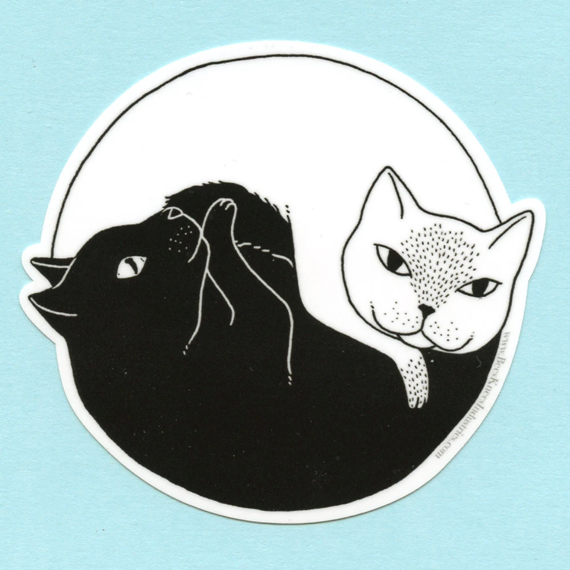 A sticker of one white cat and one black cat in a yin yang shape. 