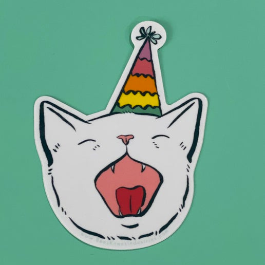 A sticker of a cat with its mouth open wearing a rainbow party hat. 