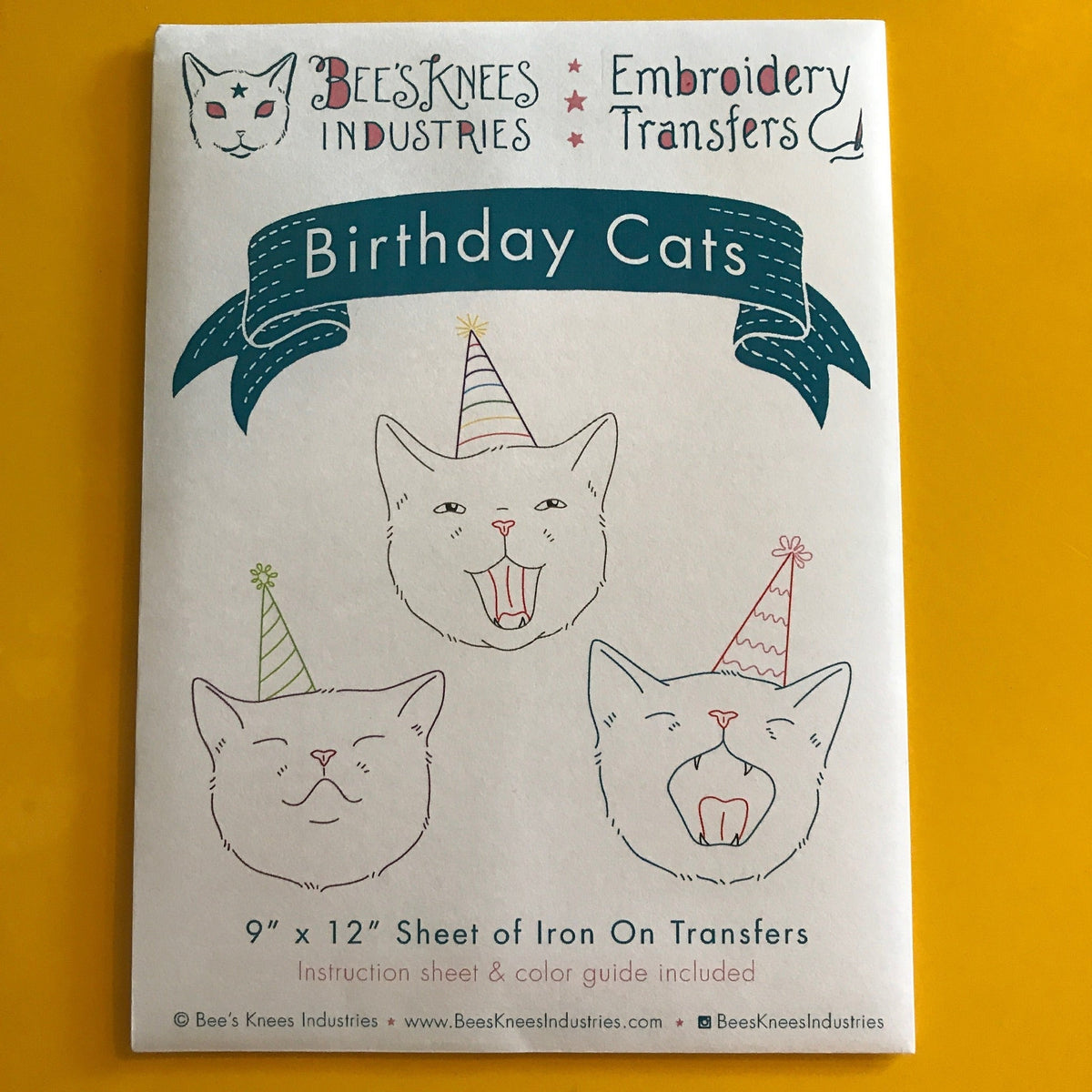 A white envelope that says "Bee's Knees Industries Embroidery Transfers: Birthday Cats" and has illustrations of three cats wearing party hats against a yellow background.