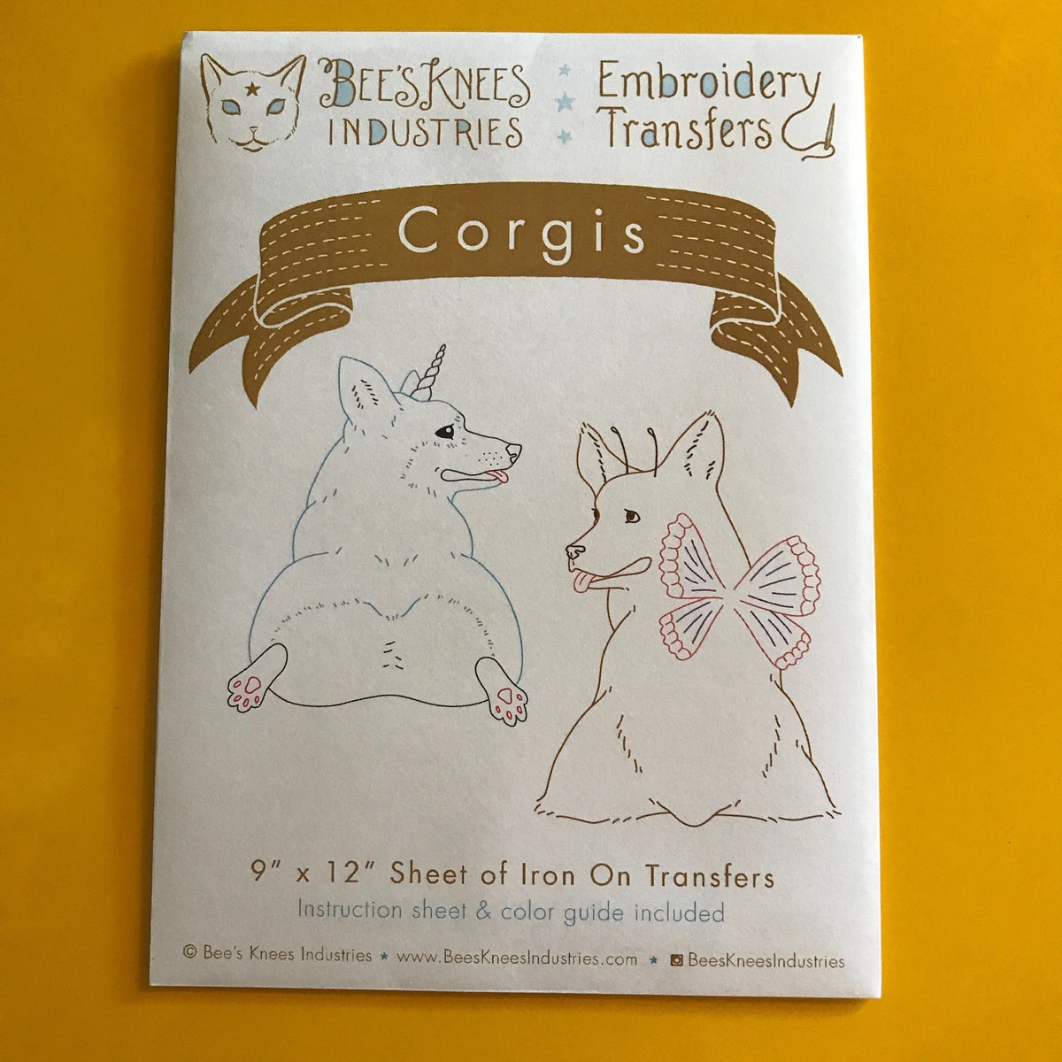 A white envelope that says "Bee's Knees Industries Embroidery Transfers: Corgis" and has illustrations of corgis against a yellow background.