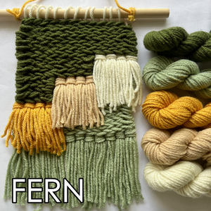 Woven yarn sample with green, yellow, and beige colors next to skeins of yarn on a white background.