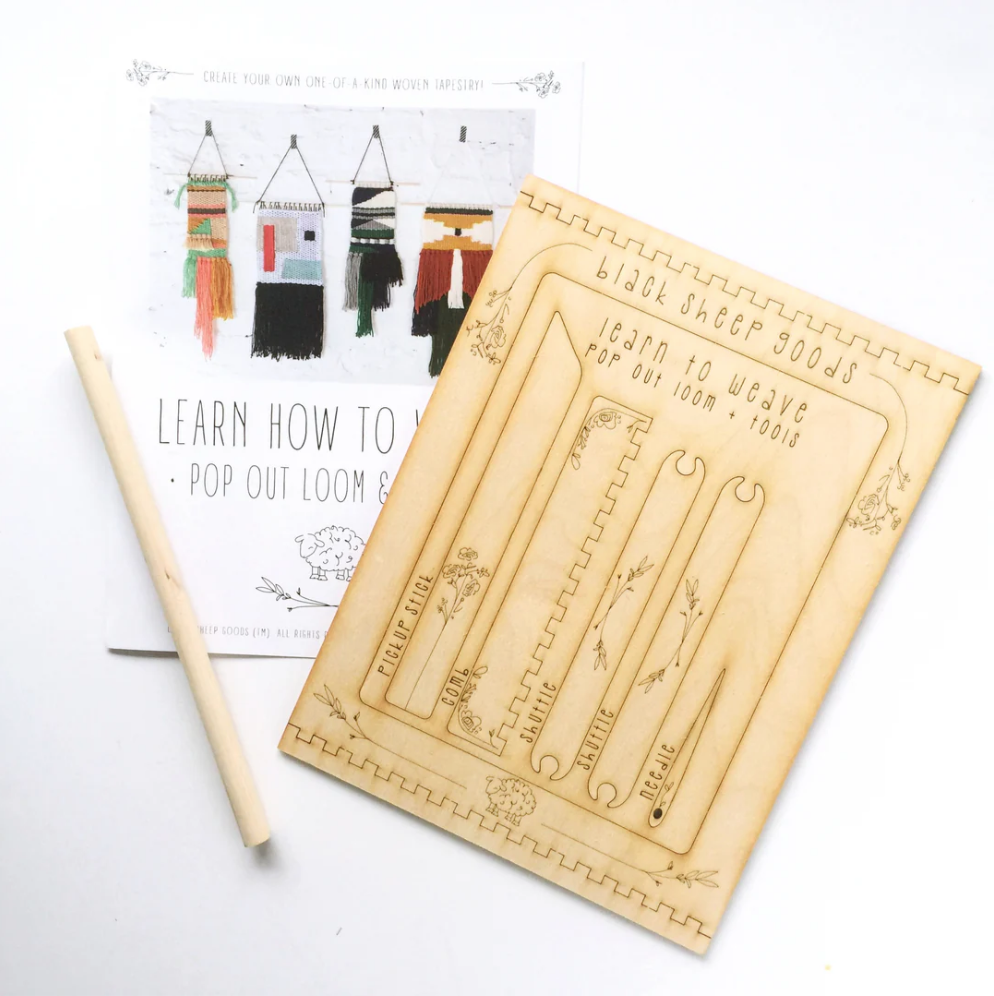 Wooden weaving loom and instruction manual on a white background