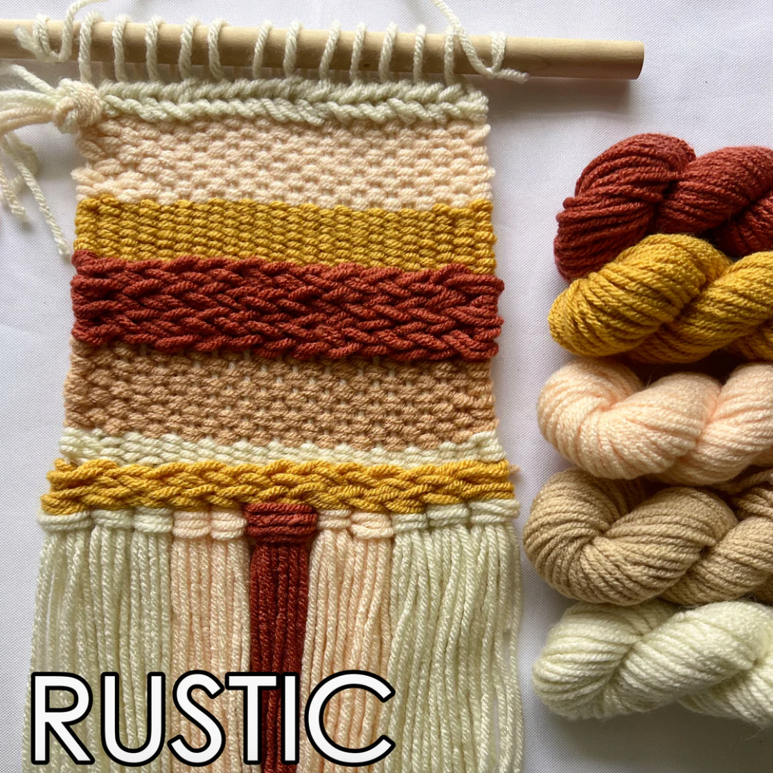 Woven wall art with rustic colors and skeins of yarn on a white background