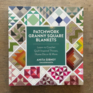 Patchwork Granny Square Blankets book by Anita Gibney, featuring a colorful quilted patchwork cover design with a central dark green title block, photographed on a wooden surface.