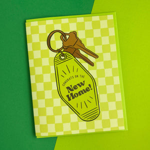 Greeting card with keys and keychain tag on a green and white checkered background