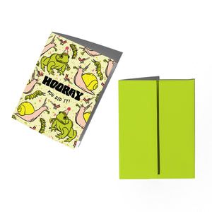 Greeting card with a colorful frog and snail design and matching lime green envelope on a white background. 