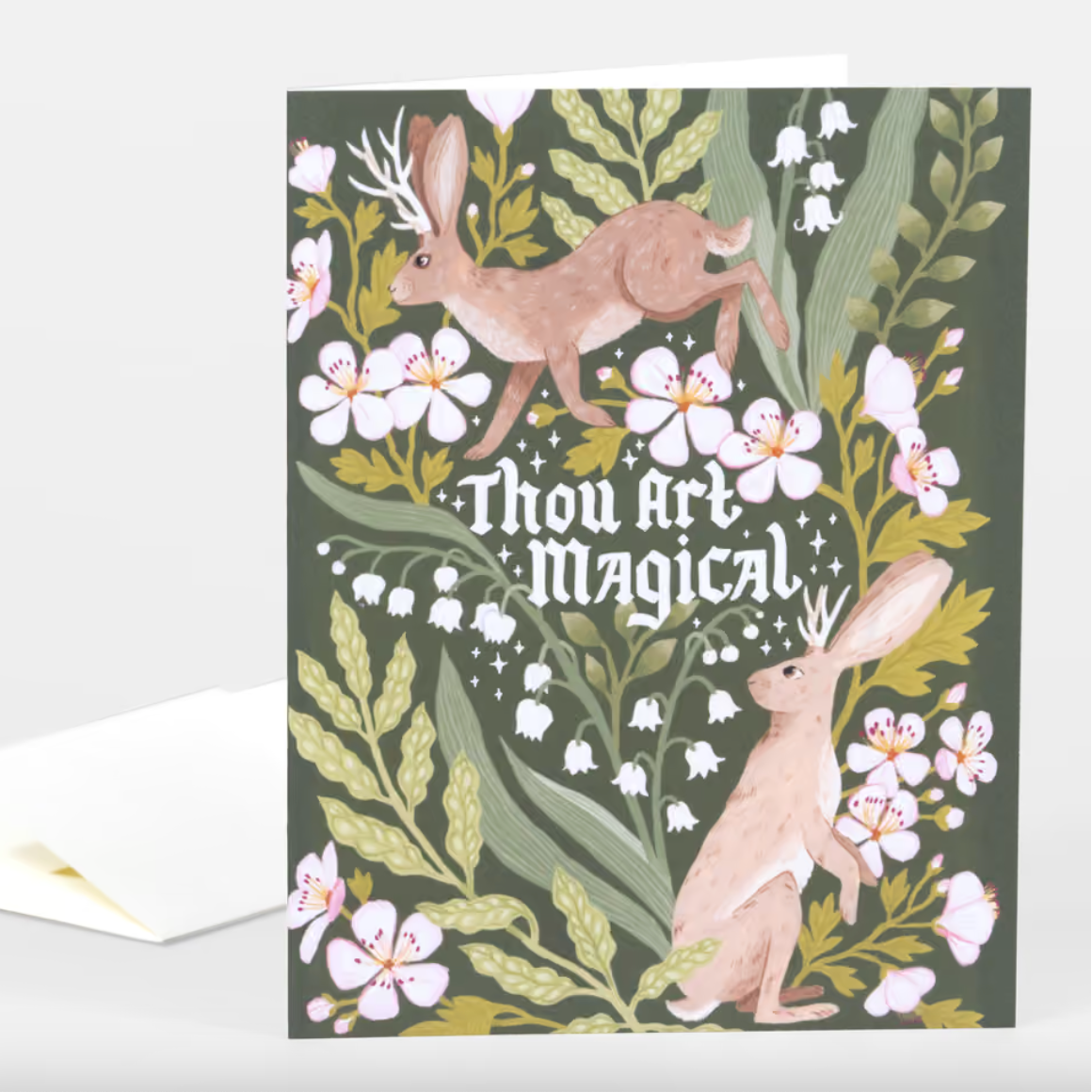 Dark green greeting card with two bunnies with antlers, floral motifs, and text that reads "Thou Art Maigical"