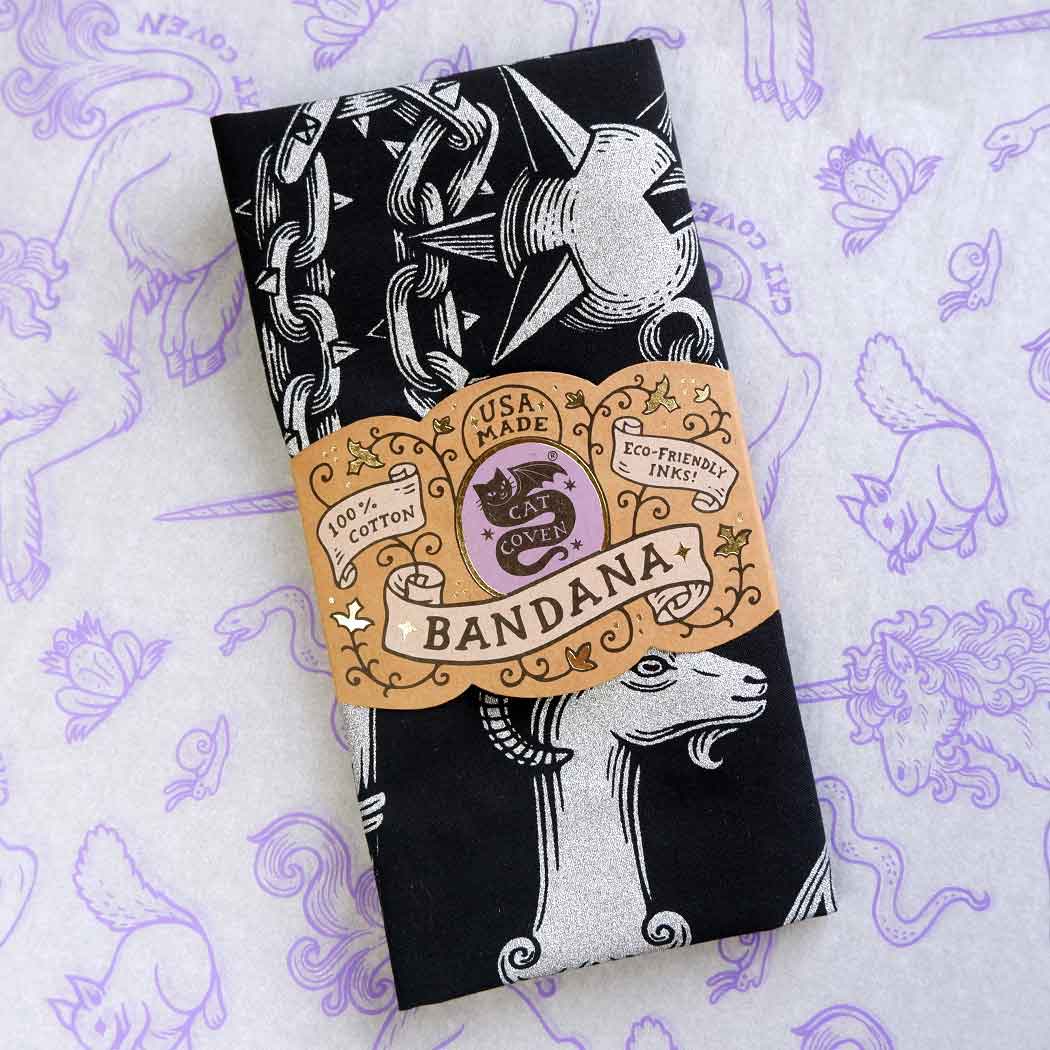 Black bandana with silver designs on a purple patterned background