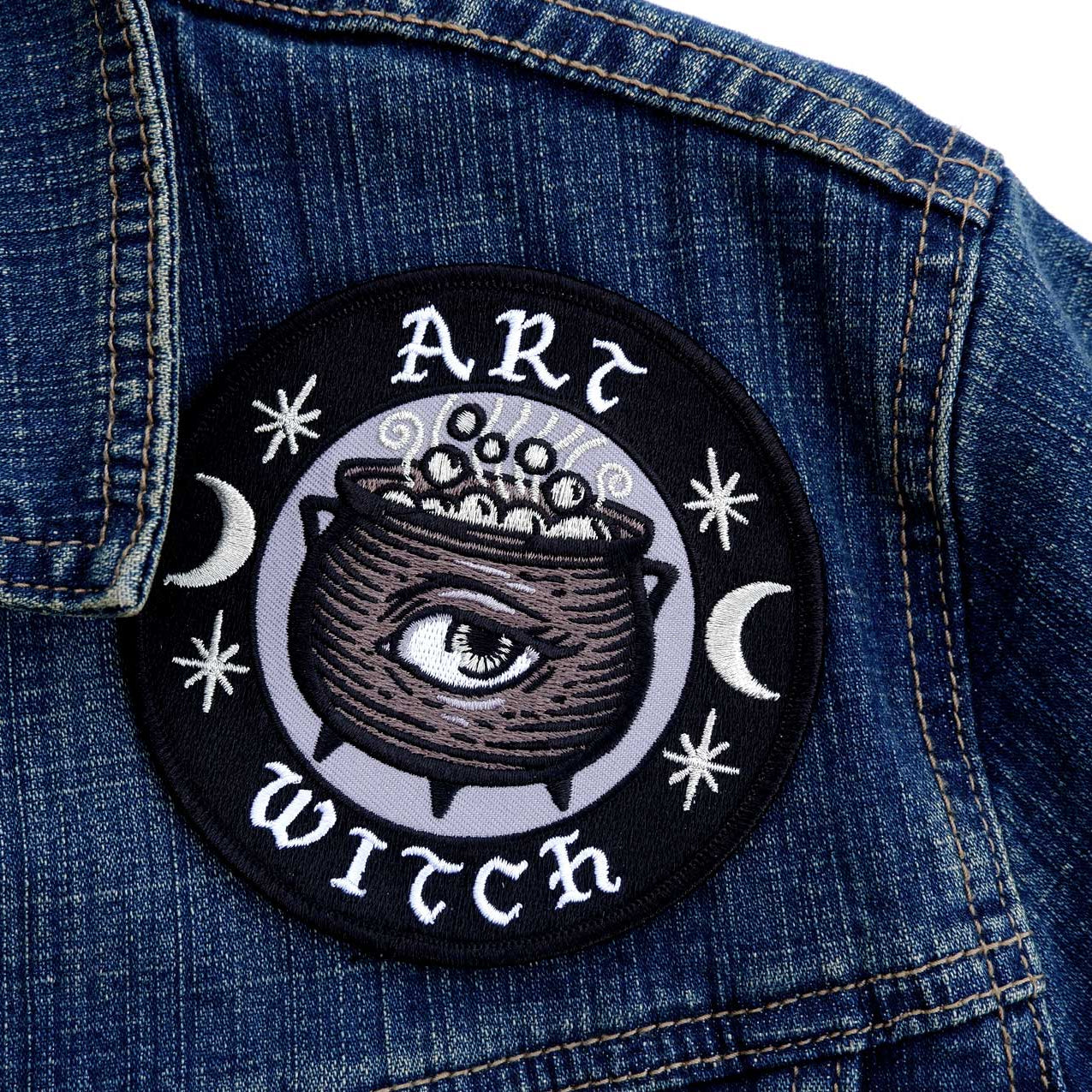 Patch with 'Art Witch' design on a denim jacket