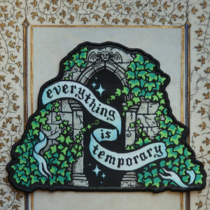 Decorative patch with archway and ivy design and text that says "everything is temporary" on a decorative background