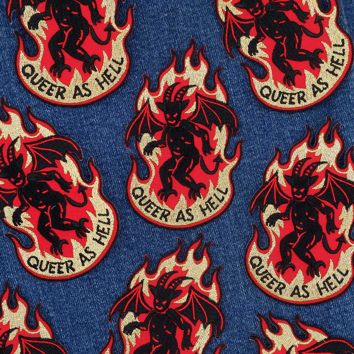 Pattern of devils with flames and 'Queer as Hell' text on a denim background
