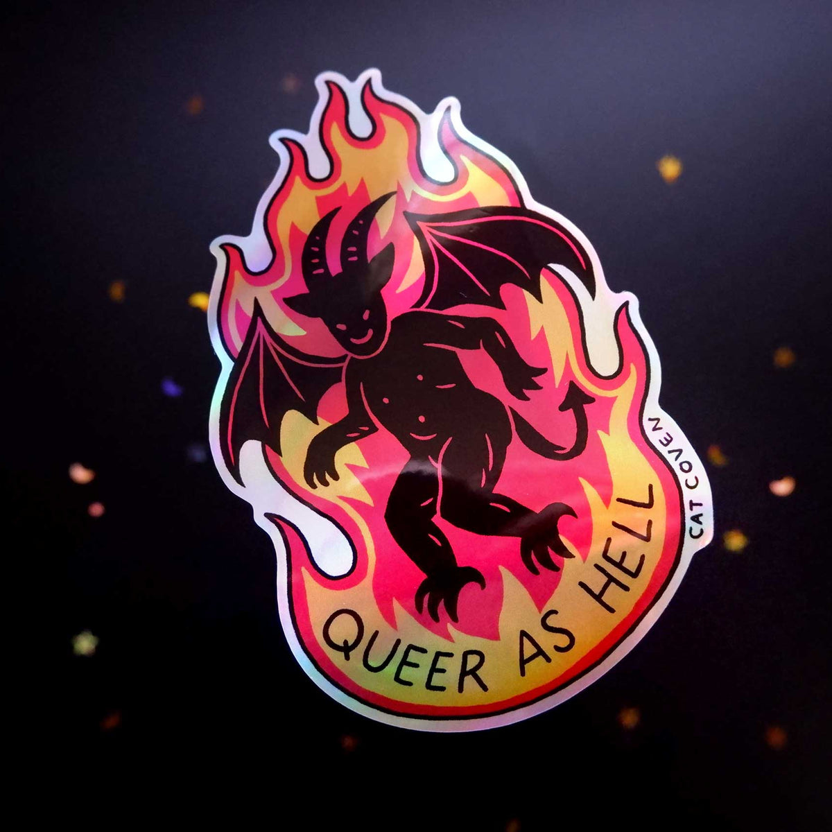 Sticker with a devil design and 'Queer as Hell' text on a dark background