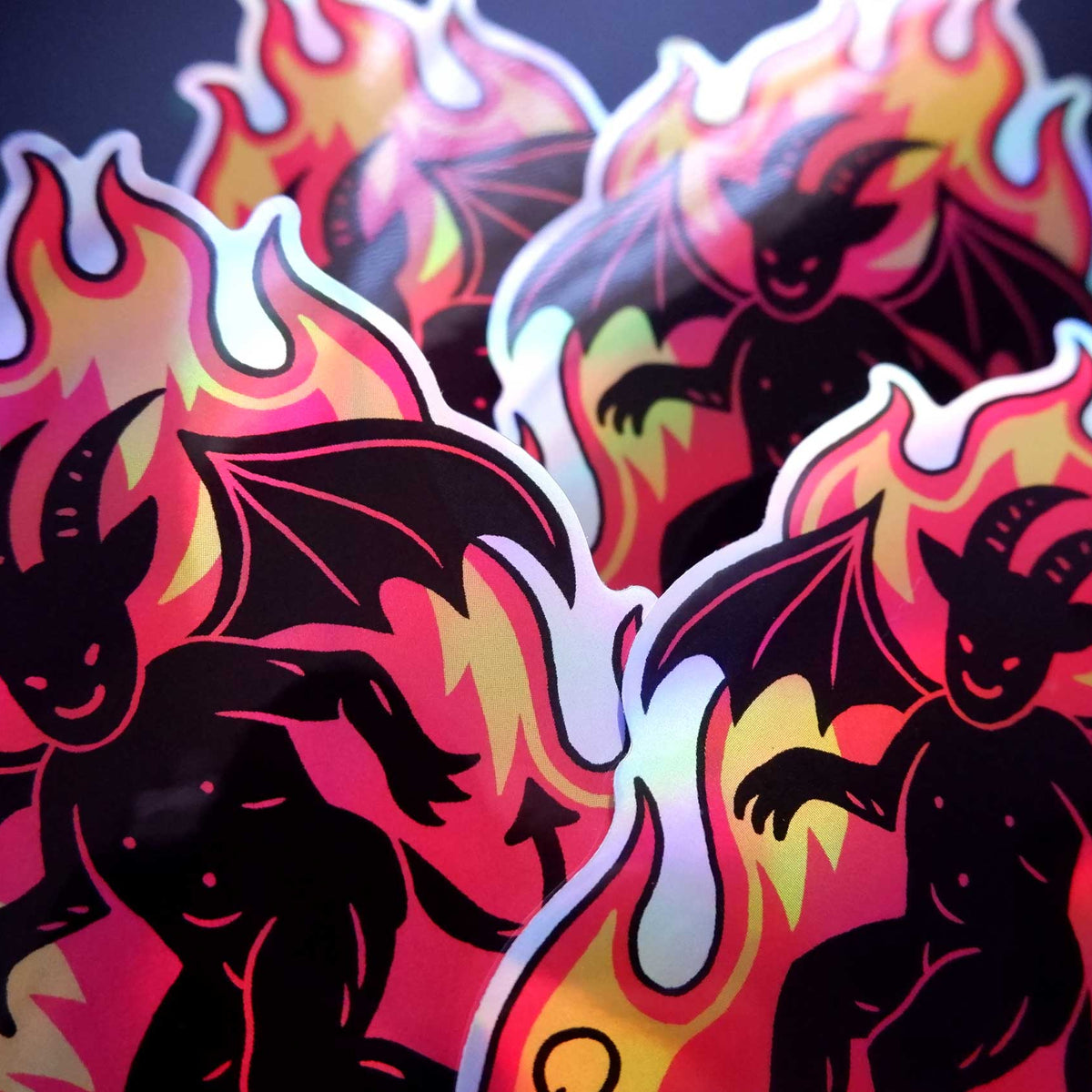 Sticker design of a black demon with flames on a colorful background