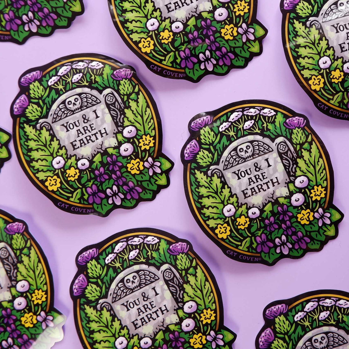 Decorative stickers with 'You & I Are Earth' text on a purple background