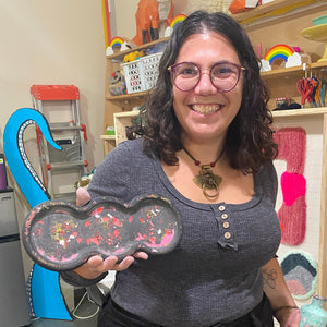 Person holding a decorative tray in a craft store setting.
