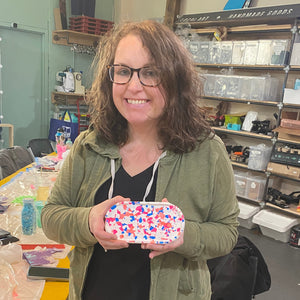 Person holding a colorful terrazzo tray in a store setting.