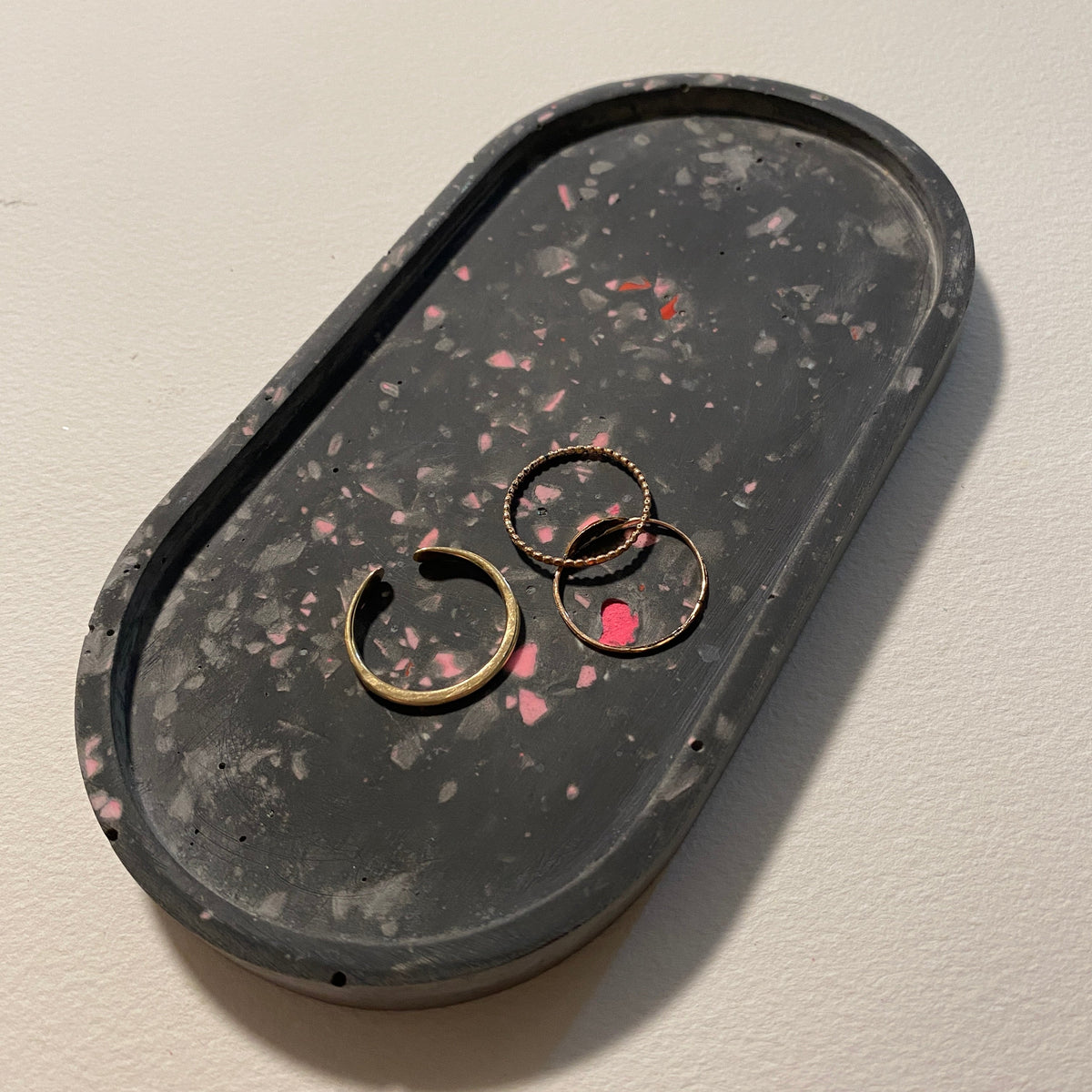 A terrazzo trinket tray with rings inside. 