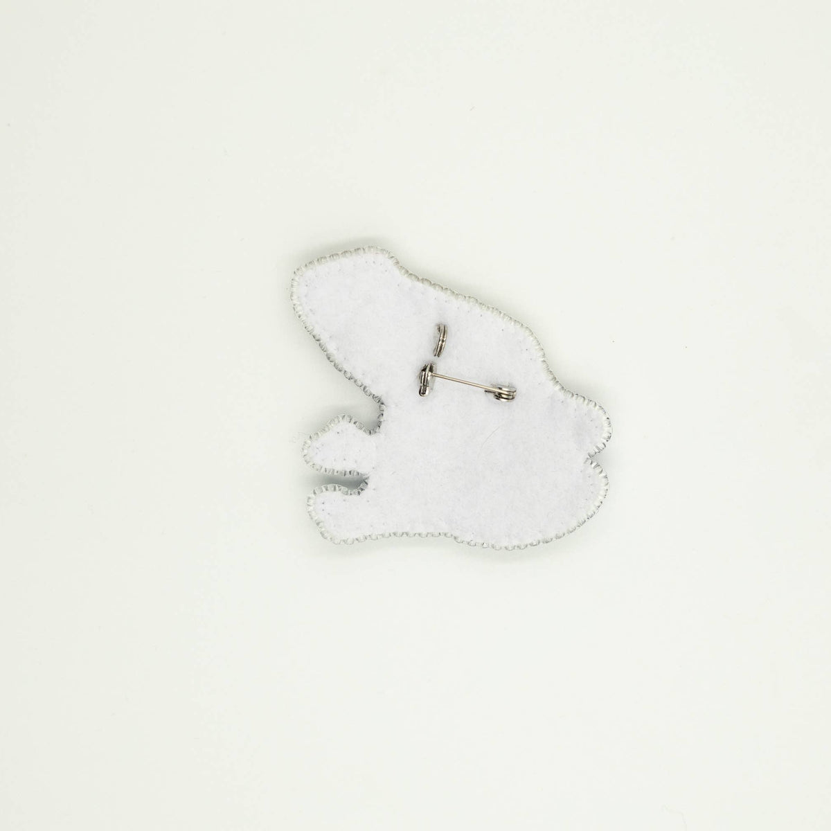 Back of the beaded frog brooch, including white felt shape and silver brooch pin. 