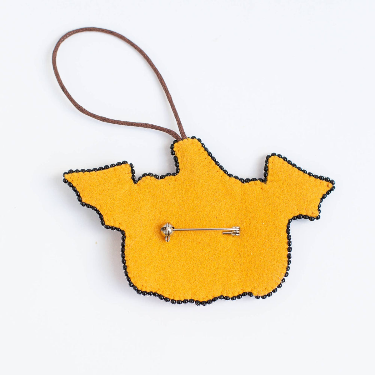 A yellow felt pinback accessory with a brown loop and black trim, shown on a plain white background.