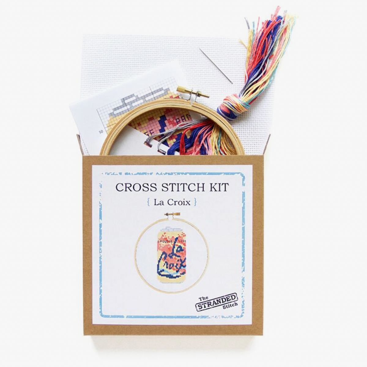 Cross stitch kit with embroidery hoop and colorful threads on a white background