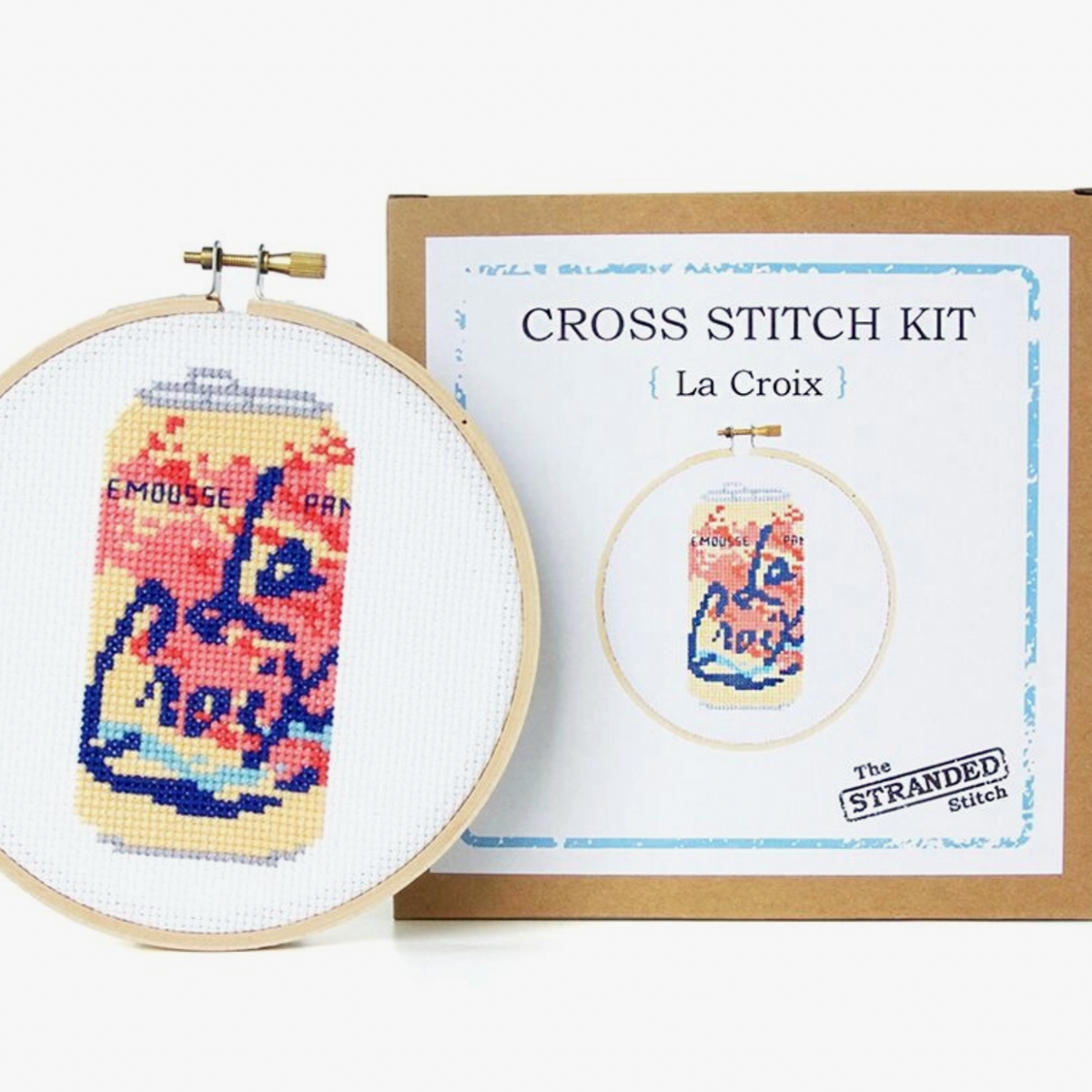Cross stitch kit with La Croix design in an embroidery hoop and packaging on a white background
