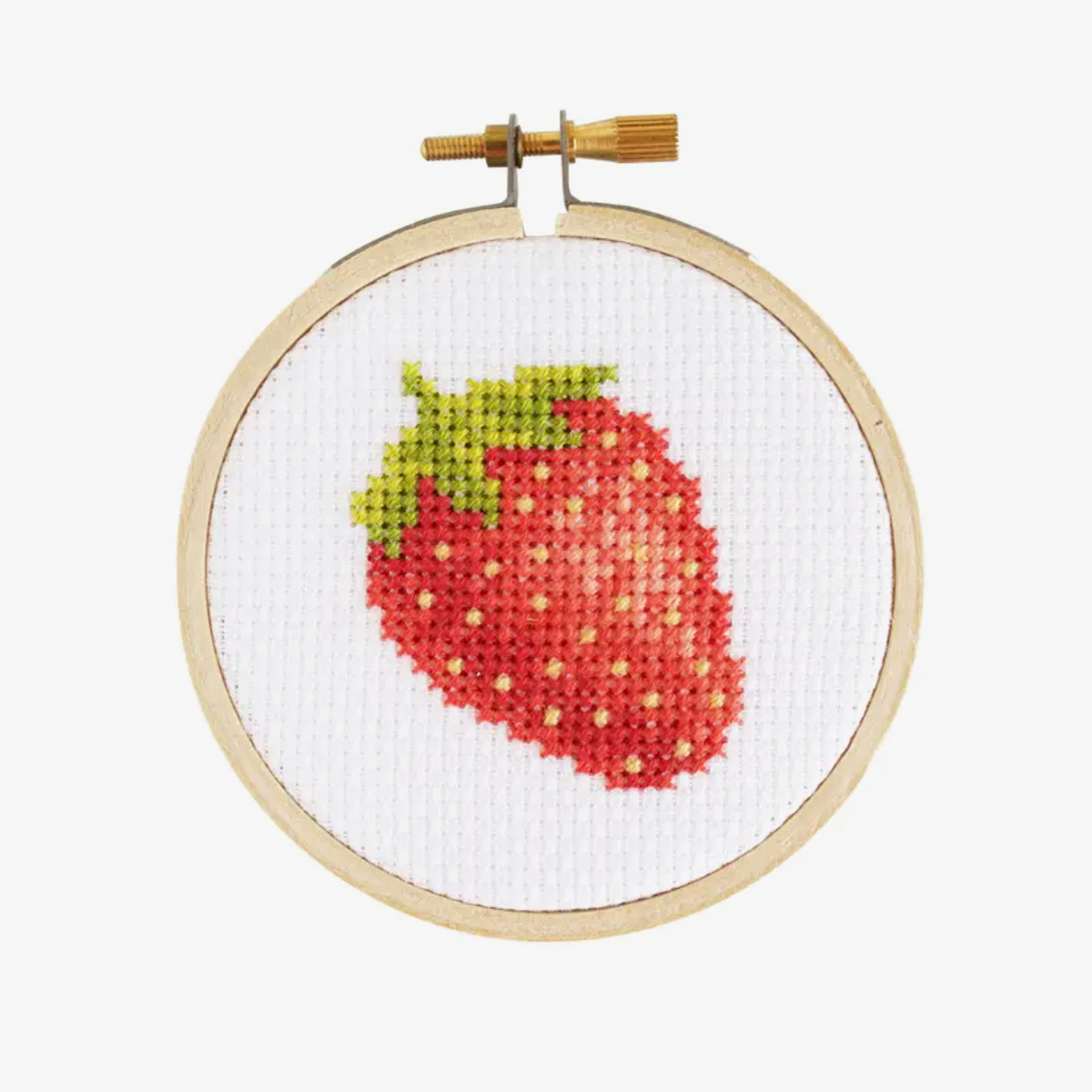 A small cross-stitch kit with a completed strawberry design displayed in a 3-inch hoop.
