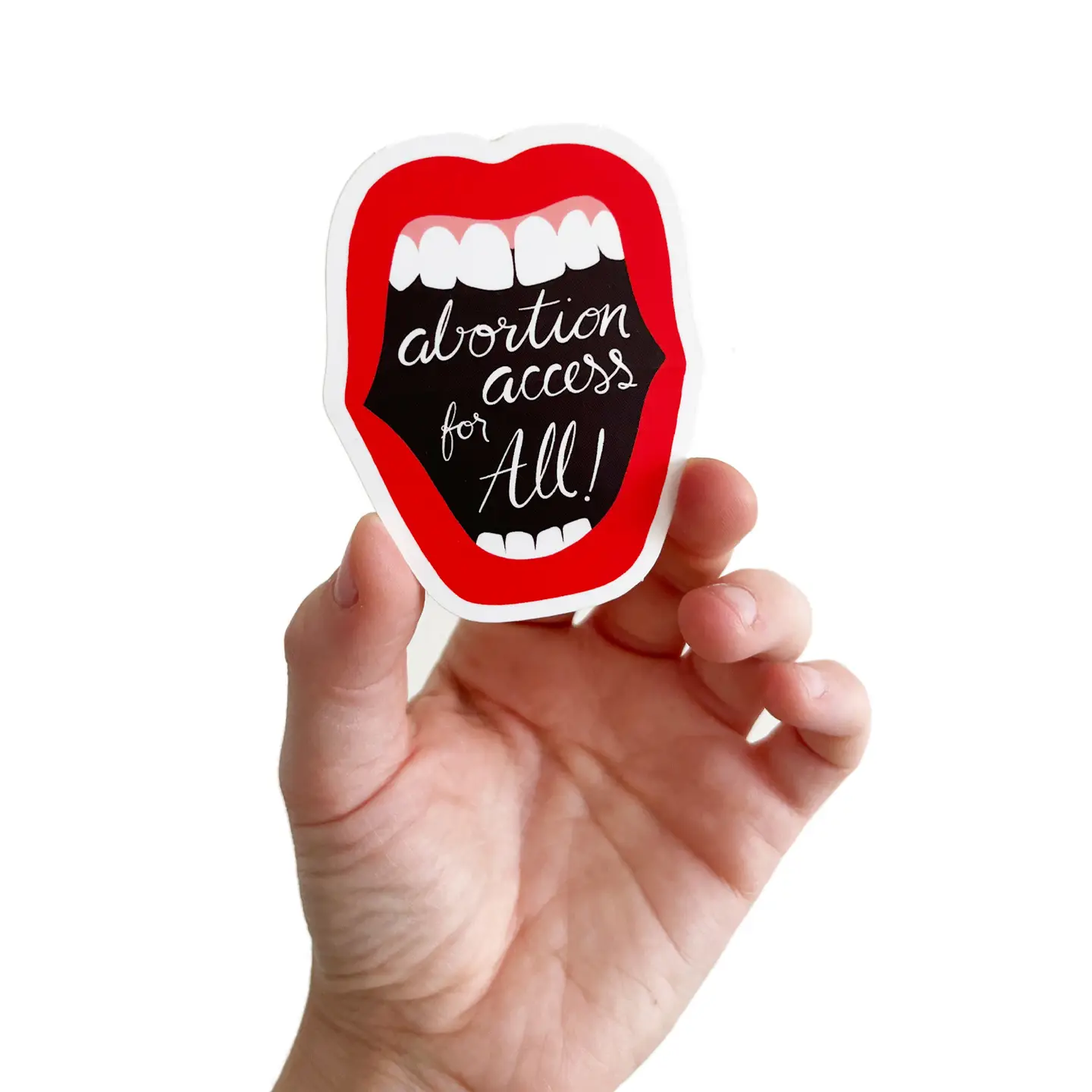 A sticker of a mouth with red lips that says "abortion access for all!" inside